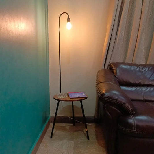 Fancy floor lamp with built-in side table placed beside a sofa in living room
