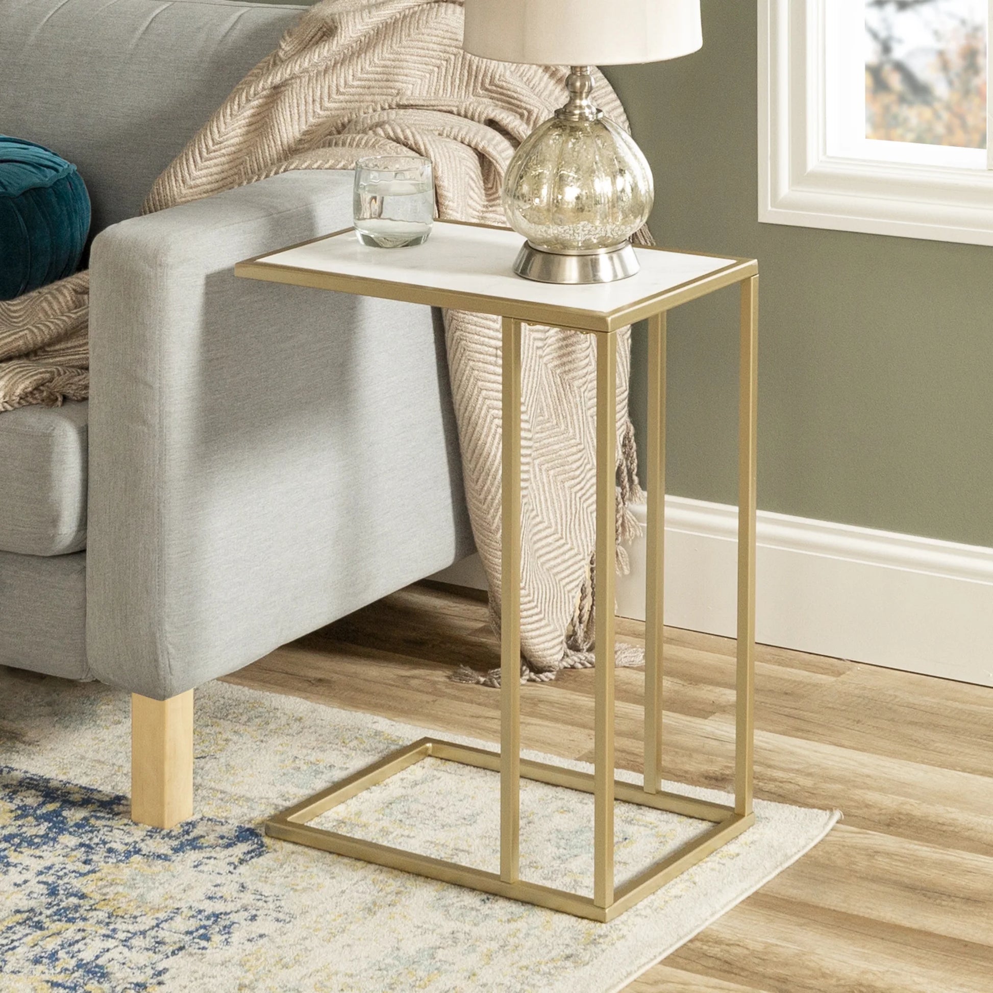C-shape accent table with gold frame and marble-textured top in a modern room – MetalX