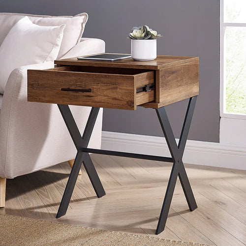 Front view of metal and wood side table with drawer placed beside a bed in real home setup – MetalX