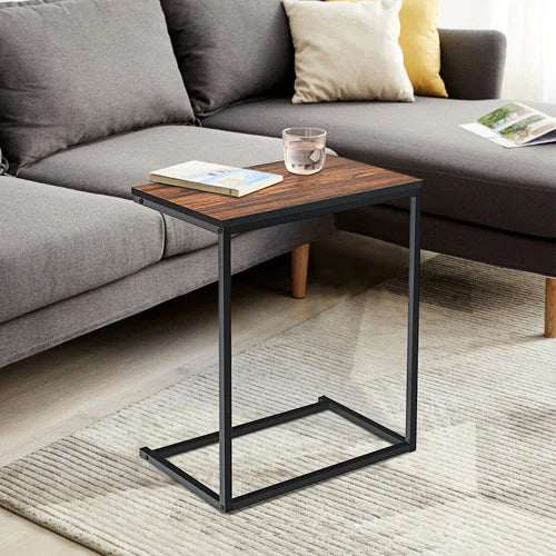 Industrial C-shaped end table with walnut top and black frame placed beside a couch – MetalX