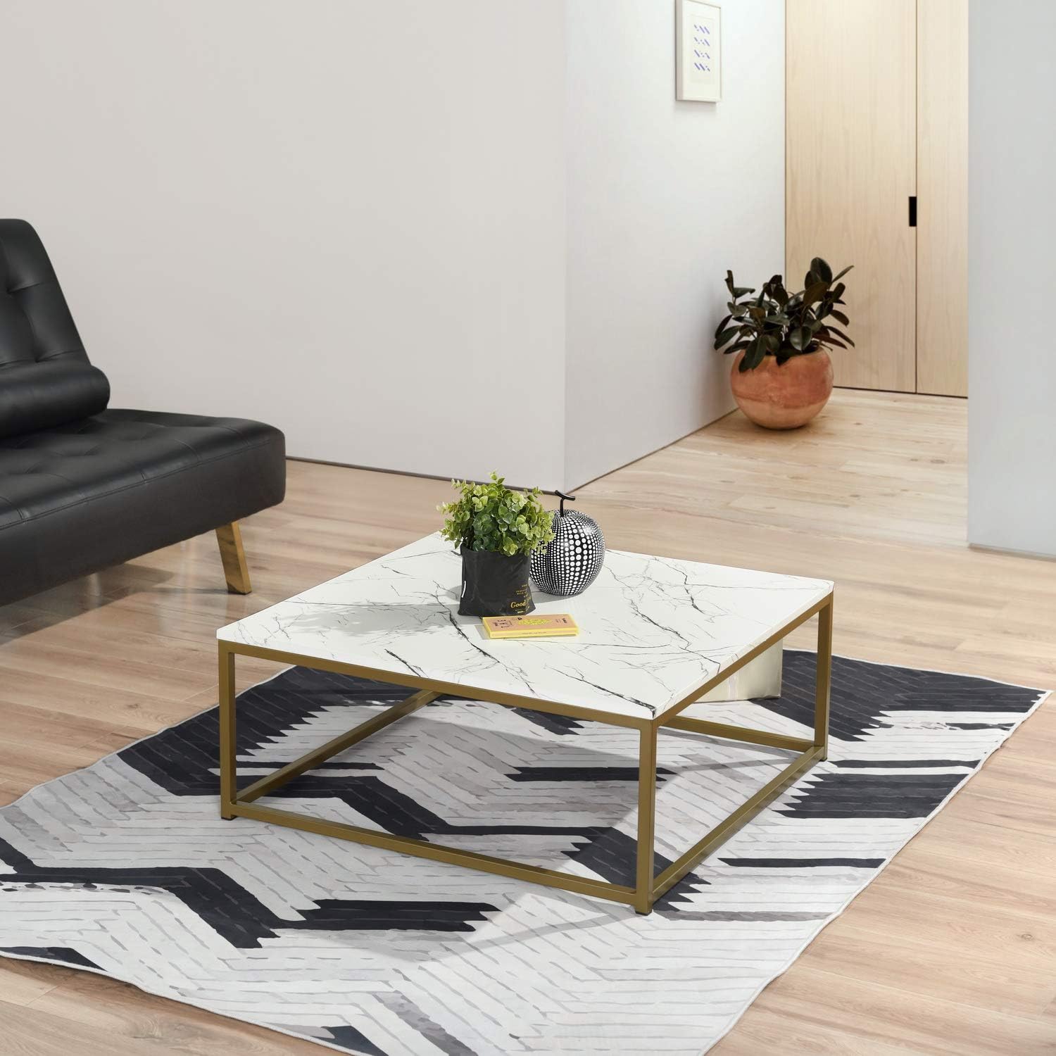 Square marble coffee table with gold frame by MetalX, displayed in real-world living room setup