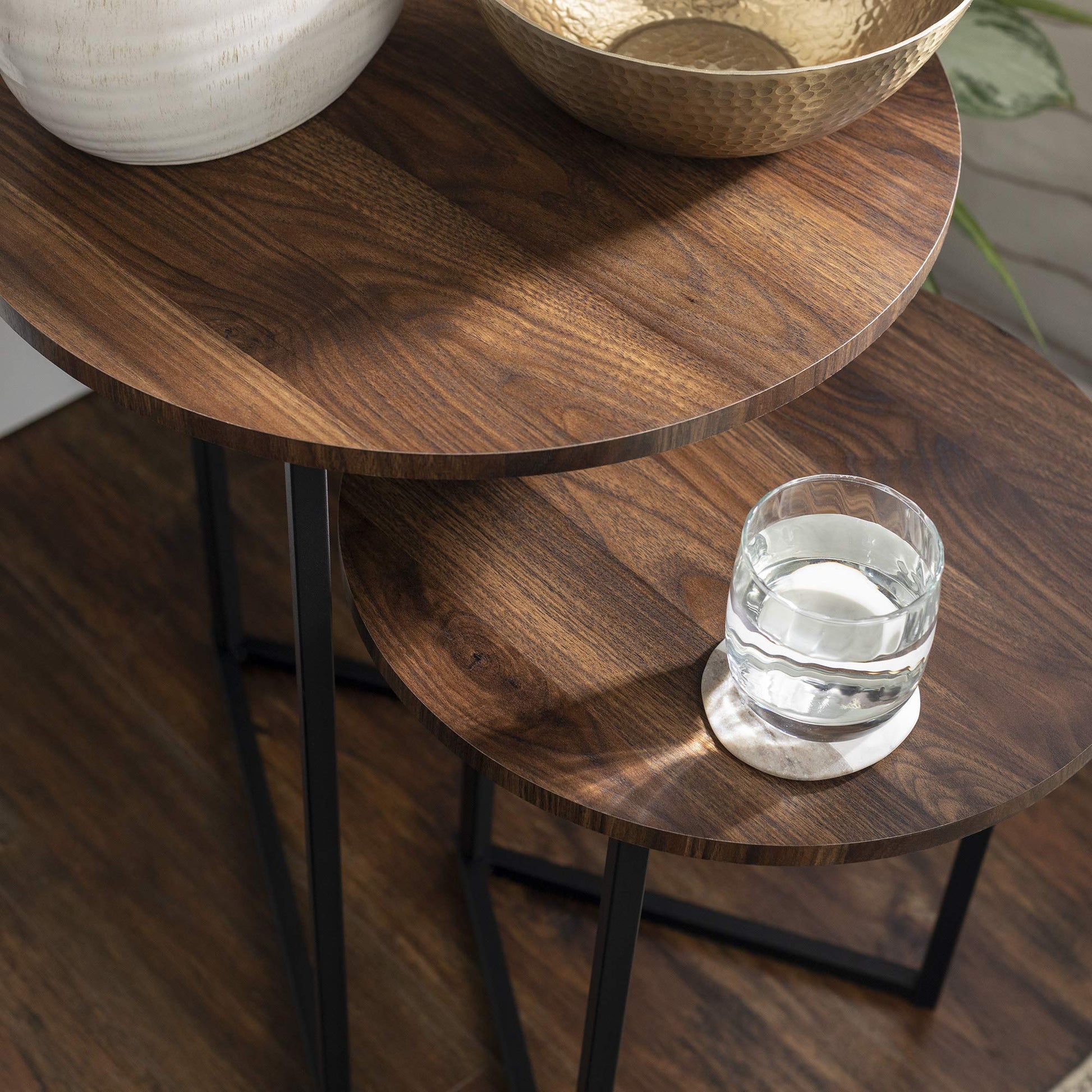 Close-up of walnut finish top on nesting table with black metal frame β real-world home setting