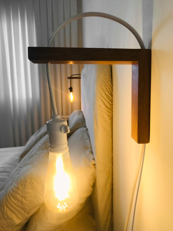 Wooden bedside lamp fixed beside bed with warm light glow