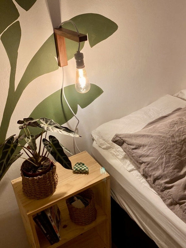 Minimalist wall-mounted wooden bedside lamp in cozy bedroom
