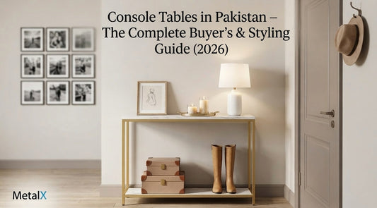 A minimalist industrial console table styled with a photo, lamp, and boots in a contemporary Pakistani foyer