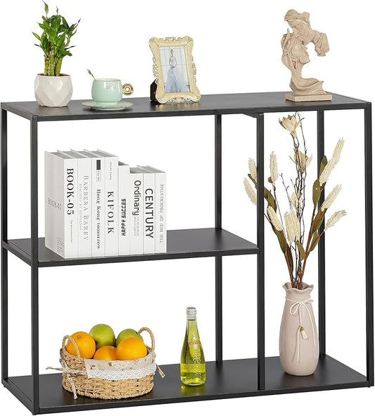 Black console table with books, a vase, and decorative items on a white background