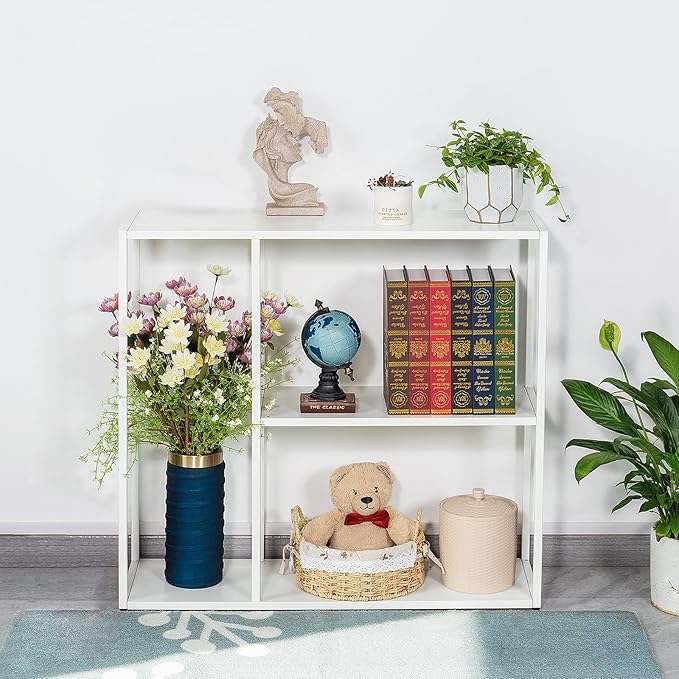 White bookshelf with decorative items including books, a teddy bear, and plants.