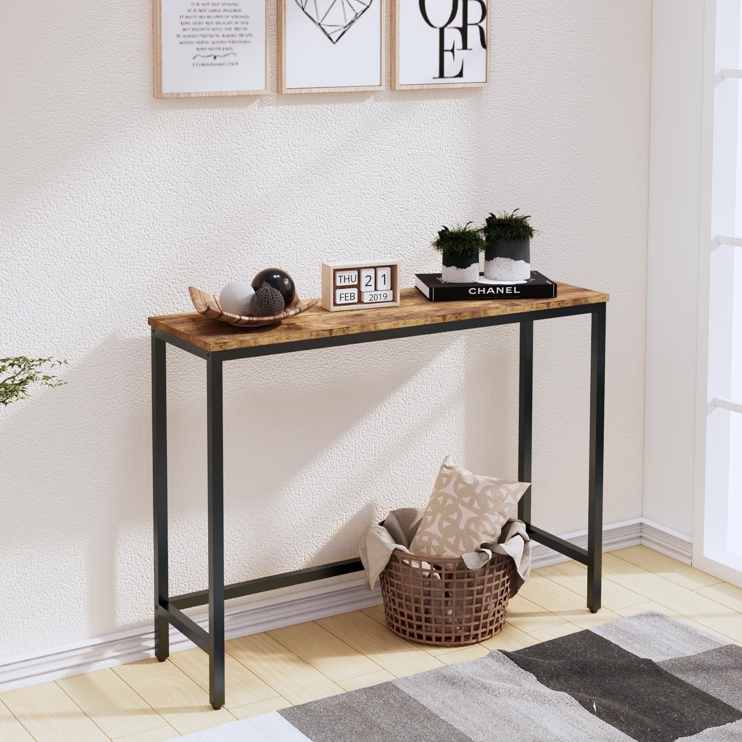 Console table with decorative items in a room with framed art on the wall.